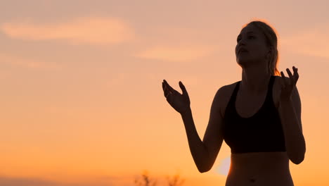 Athletic-girl-playing-beach-volleyball-jumps-in-the-air-and-strikes-the-ball-over-the-net-on-a-beautiful-summer-evening.-Caucasian-woman-score-a-point.